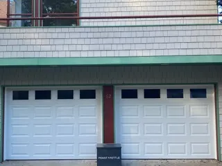 Matched pair of insulated white garage doors on a Cape Cod home